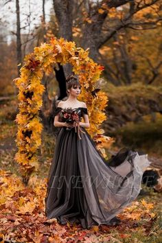 a woman in an off the shoulder dress is posing for a photo with leaves around her