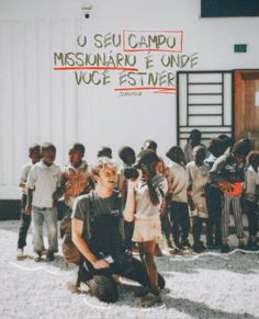 a group of children standing in front of a white building with the words u seu campdu missanarir e unde voce written on it