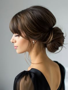 The elegant sleek low bun with curtain bangs is a classic choice that radiates sophistication and poise. This hairstyle features a smooth, polished bun positioned at the nape of the neck, paired with soft, parted bangs that frame the face. Ideal for formal events like weddings or black-tie occasions, this look is perfect for those with straight hair or those who prefer a sleek and refined style. It suits oval and heart-shaped faces, enhancing their natural symmetry. The curtain bangs, especially, draw attention to the eyes, making it a great option for those with striking eye colors. Curtain Bangs Updo Wedding, Bangs Hair Up Do, Low Updo With Bangs, Curtain Bangs Low Bun, Wedding Hair Curtain Bangs, Low Bun With Curtain Bangs, Formal Updo With Bangs, Bridal Hair With Fringe, Formal Hair With Bangs