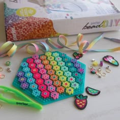 there is a craft kit with beads and scissors on the table next to some other items