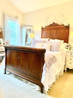 a bedroom with a bed, dressers and mirror in it's center area