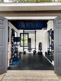 an open garage door shows the inside of a home gym