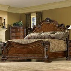 a large wooden bed sitting in a bedroom next to a night stand and dressers