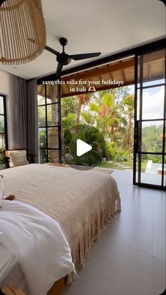 a bed sitting in a bedroom next to a sliding glass door with an open window