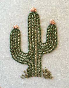 an embroidered cactus with pink flowers on it