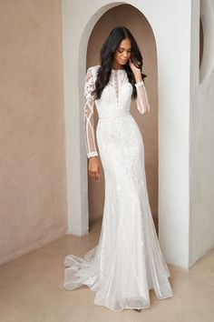 a woman in a white wedding dress posing for the camera