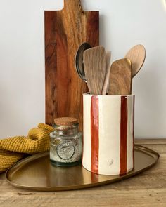 wooden spoons and utensils in a ceramic container