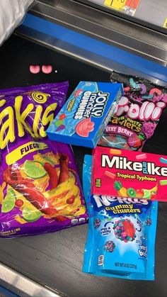 some candy is sitting on top of a shelf next to other snacks and candies