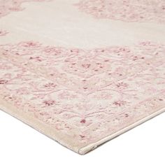 a pink and white rug with an intricate design on the bottom, is shown in close up