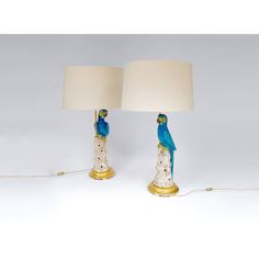 two lamps with blue parrots on them sitting next to each other in front of a white background