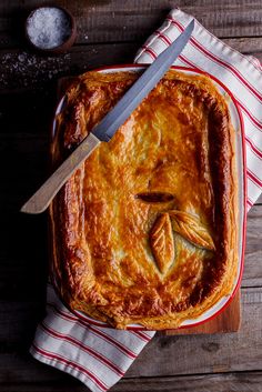 a pie on a wooden table with a knife