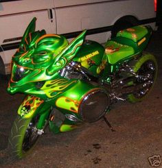 a green dragon motorcycle parked next to a white van