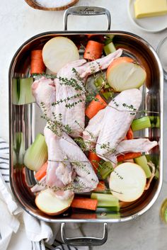 chicken, carrots and celery in a roasting pan on a table