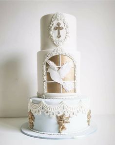 a three tiered cake with white frosting and gold decorations