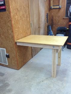 a wooden table sitting inside of a garage