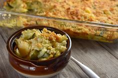 a casserole dish with broccoli and cheese in it next to a glass baking dish