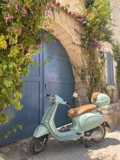 a scooter is parked in front of a blue door with pink flowers on it