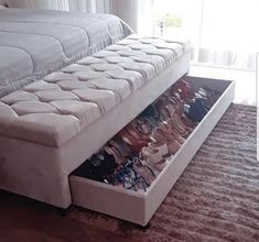 a bed sitting on top of a carpeted floor next to a drawer filled with shoes