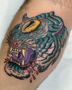 a close up of a person with a tattoo on his arm and the head of a tiger