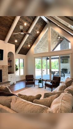 a living room filled with furniture and a flat screen tv mounted on the wall next to a fireplace