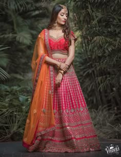 a woman in a red and orange lehenga