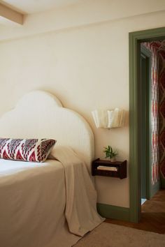 a white bed sitting next to a green door