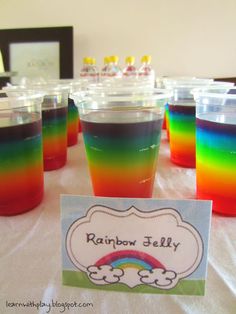 rainbow jelly cups are sitting on a table with a name tag in front of them