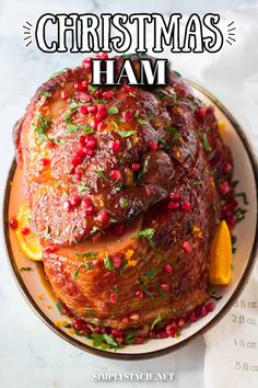 a christmas ham with pomegranates and herbs on top is featured in this recipe