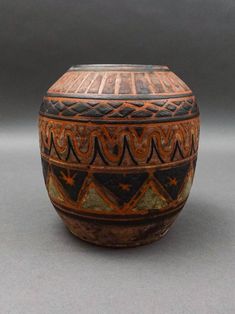 a brown and black vase sitting on top of a table