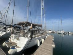 several sailboats docked at a dock on a sunny day