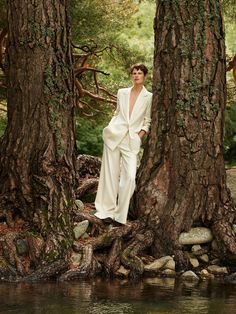 a woman standing in the middle of some trees