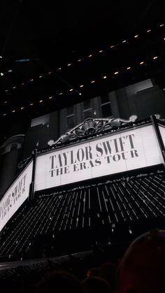 the marquee for taylor street theatre is lit up at night with people watching