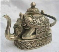 an elephant teapot is sitting on a white surface