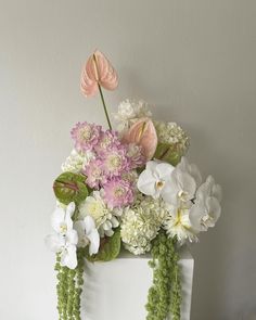 a white cake with flowers and greenery on top