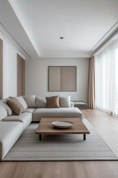 a modern living room with white couches and wooden tables in front of large windows