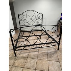 a metal bed frame sitting on top of a tiled floor