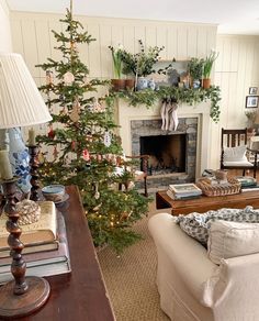 a living room filled with furniture and a christmas tree in front of a fire place