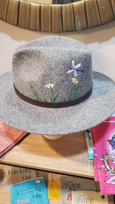 Beautiful soft gray felted fedora hat. Hand embroidered flora and fauna design stitches into the crown of the hat.  22 inches inside the crown with adjustable ribbon option.  Faux leather strap, removable.  One size fits most. Adjustable Felt Fedora Hat, Adjustable Felt Fedora, Adjustable Felt Hat With Flat Brim, Gray Wide Brim Hat With Adjustable Fit, Gray Adjustable Flat Brim Fedora, Adjustable Gray Wide Brim Hat Bands, Gray Wide Brim Adjustable Hat, Spring Fedora Felt Hat, Spring Felt Fedora Hat