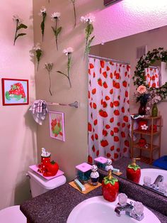 a bathroom decorated in pink and red with flowers on the shower curtain