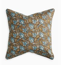 a blue and brown floral pillow on a white background