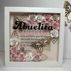 there is a white frame with pink and white flowers in front of the words abuelia