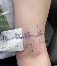 a person with a tattoo on their arm holding onto a piece of paper that is taped to the wrist