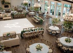 a large room with tables, chairs and chandeliers