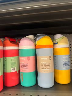 several different colored water bottles are on the shelf next to each other in a store