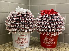 two red and white buckets with christmas decorations on them