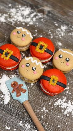 several decorated cookies sitting on top of a wooden table next to a cookie spatula