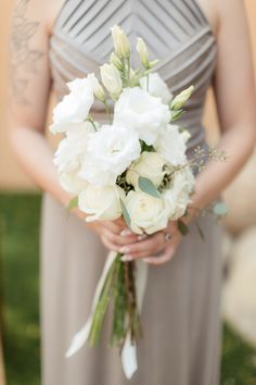 the bridesmaid is holding her bouquet of white flowers