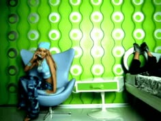 two women sitting on chairs in front of a green and white wallpapered room