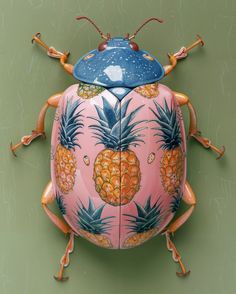 a pink and blue bug with pineapples on it's back