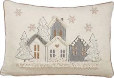 a white pillow with a house and trees on the front, in snowflakes